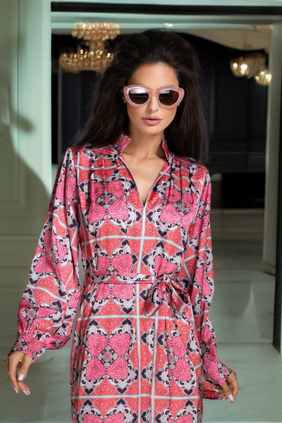 Woman in a pink patterned dress standing in an elegant interior setting