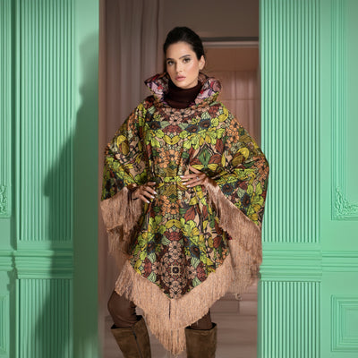 Woman wearing a patterned coat standing in a room with green walls.